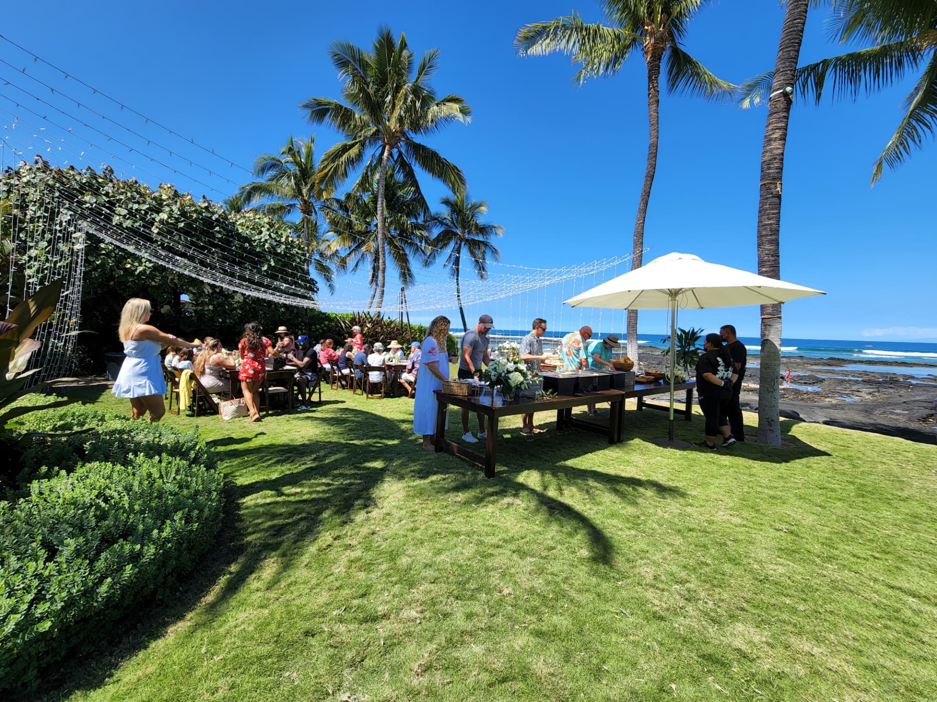 Outdoor wedding reception on a Hawaiian beachfront lawn with catering service