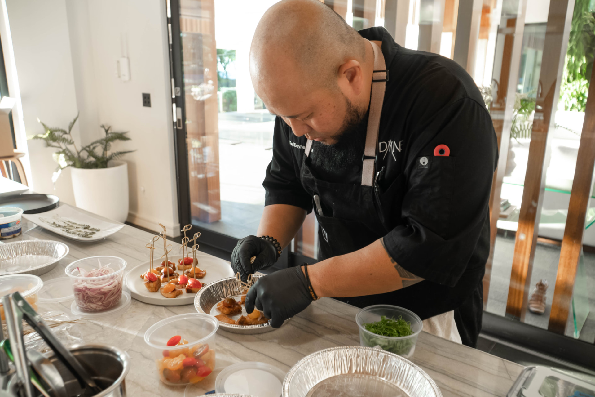 Chef Dayne plating canapés at a kitchen counter during a hands-on session