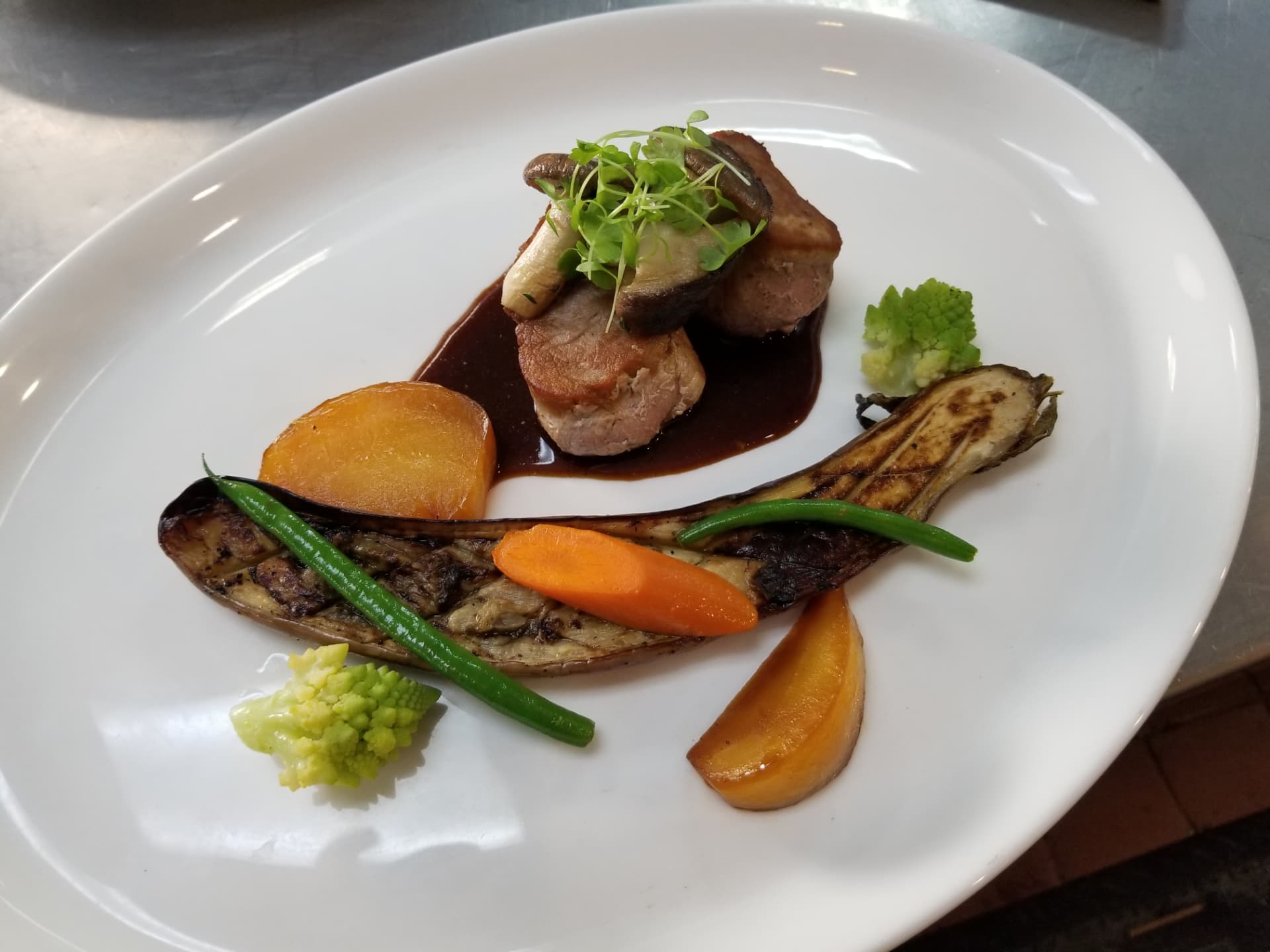 Plated meat with mushrooms, eggplant and green purée